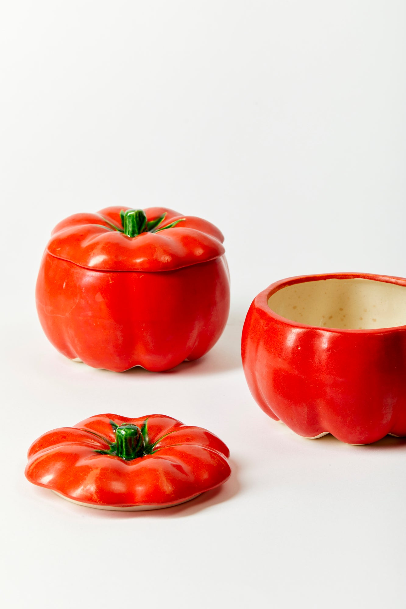 Set of 2 vintage ceramic tomato-shaped bowls against a white background. 