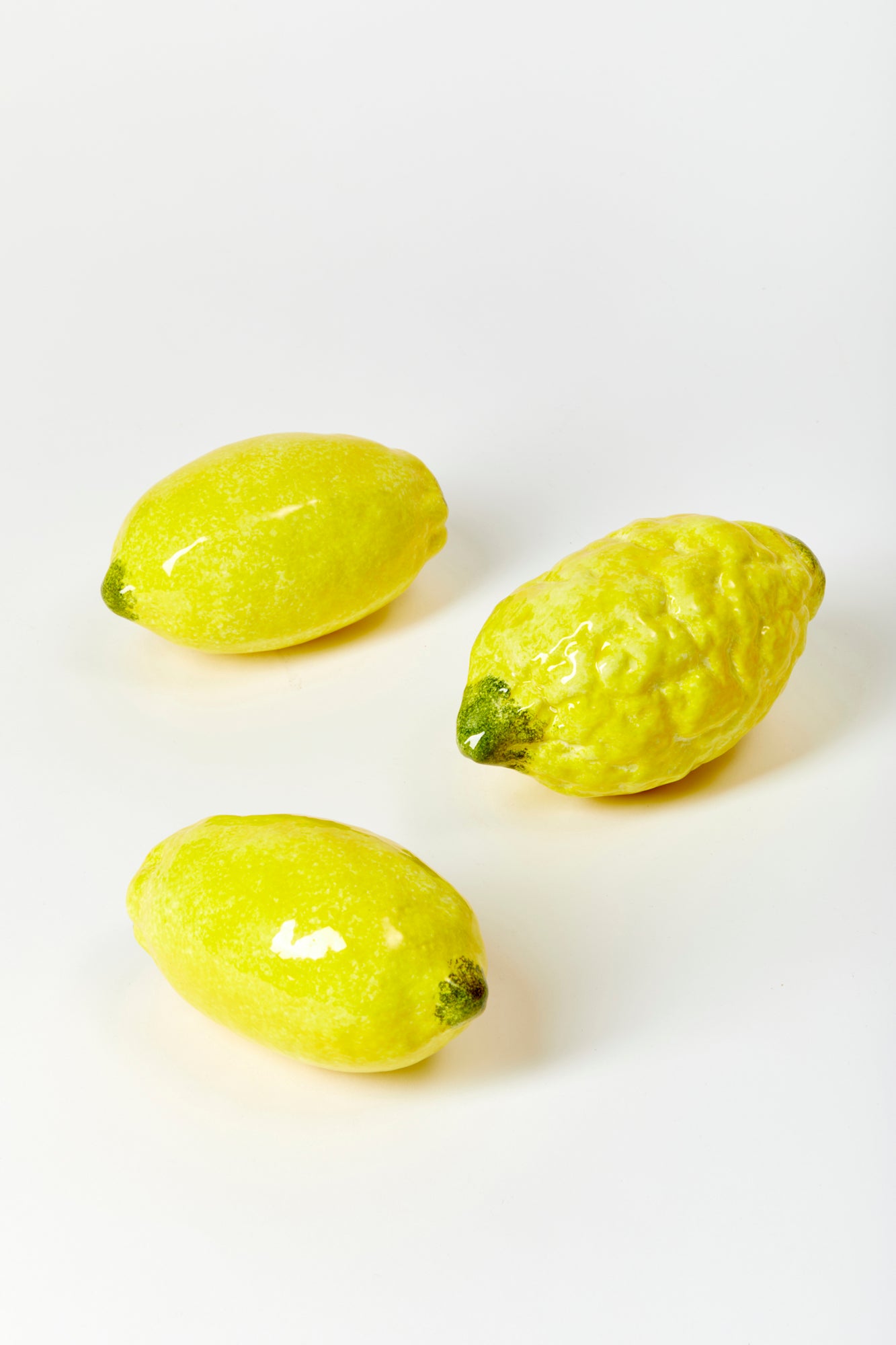 3 ceramic lemons against a white background. 