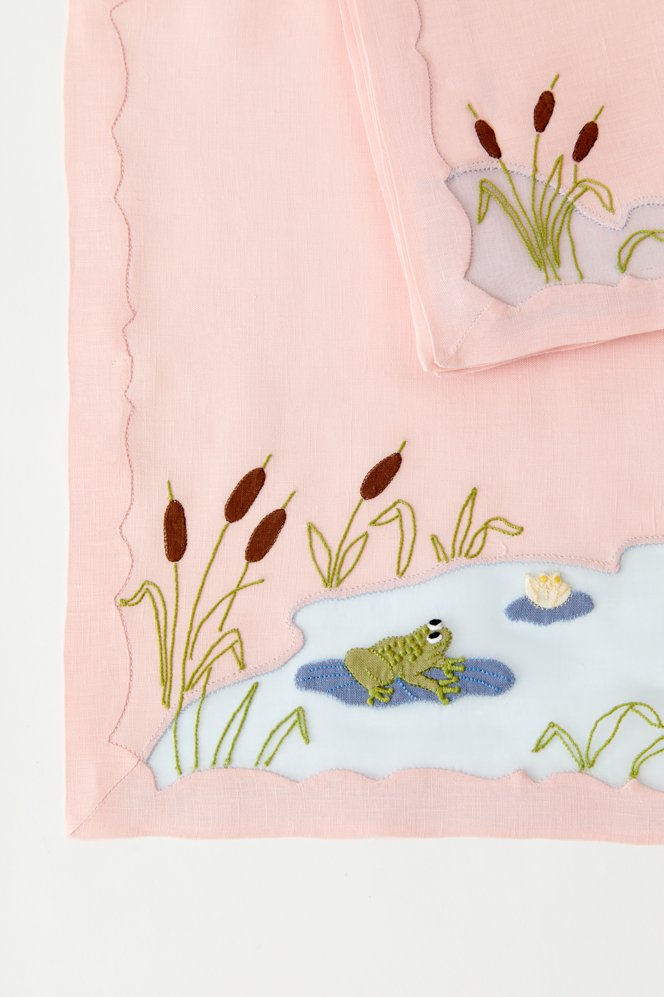 Frog in a pond placemat and dinner napkins feature French stitch appliqué made in Madeira, Portugal.