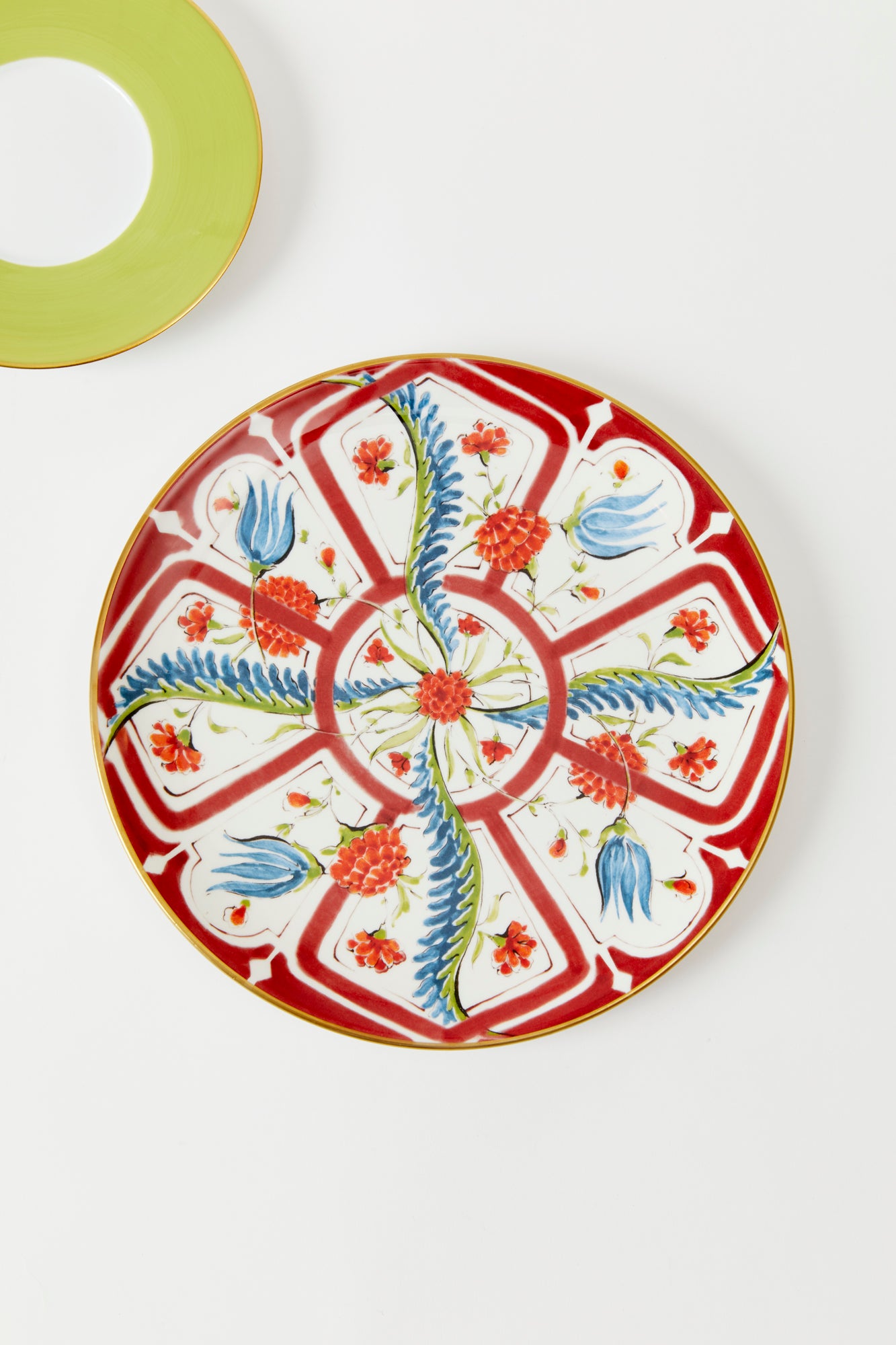Earthenware plates with a glost-fired Iznik pattern of tropical flowers, designed and hand-painted by a family of artisans in historic Milan.