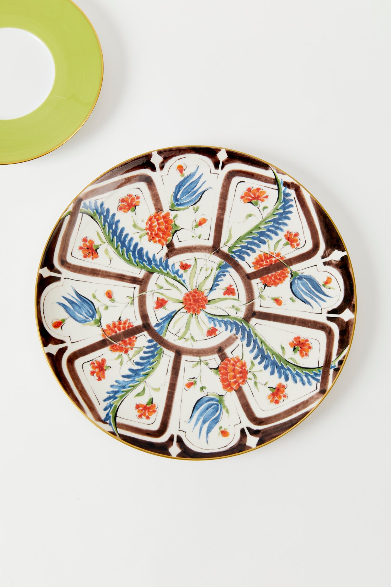 Earthenware plates with a glost-fired Iznik pattern of tropical flowers, designed and hand-painted by a family of artisans in historic Milan. 