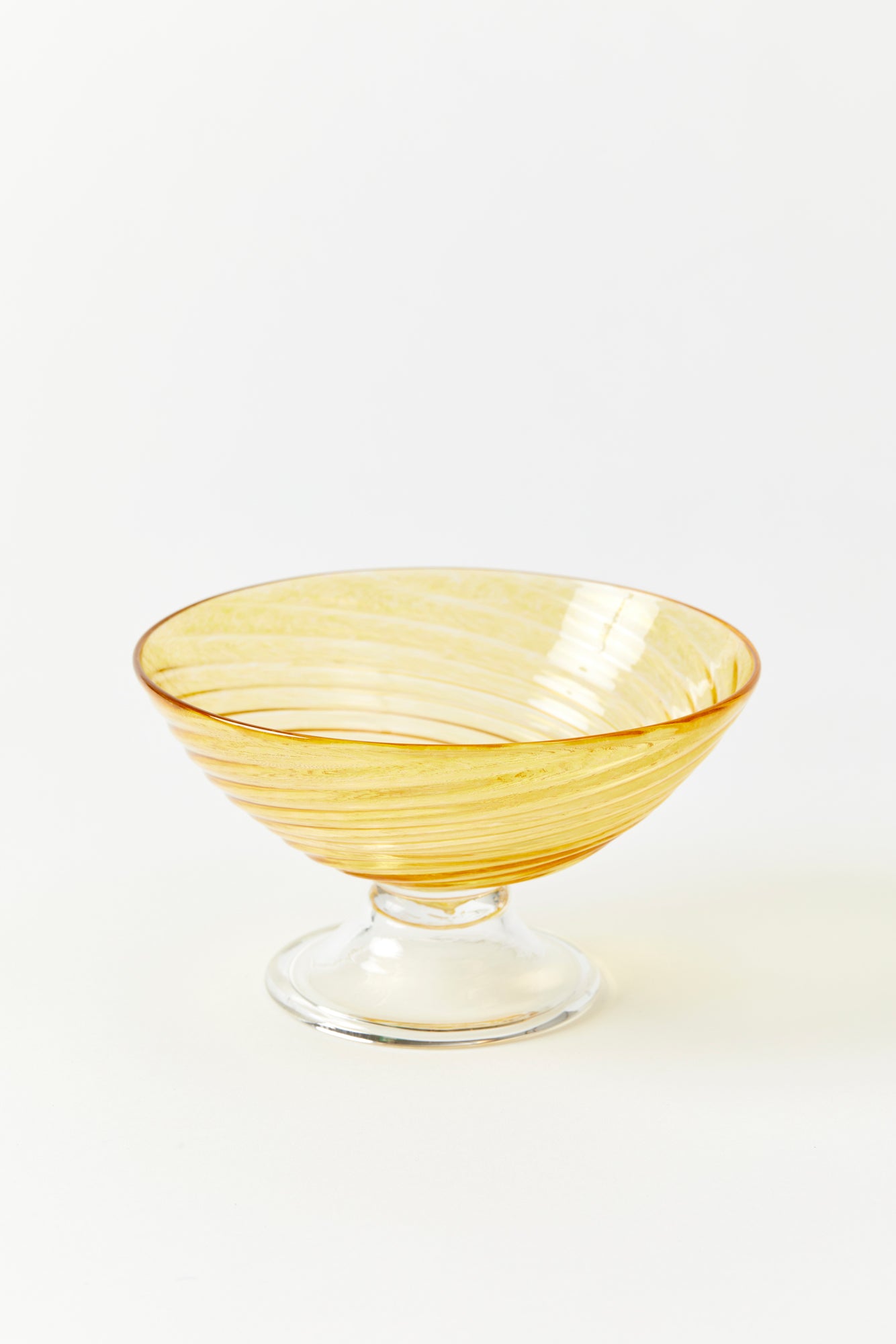 Hand blown glass dessert dish. Gold glass bowl with twisty element atop clear glass foot. Approximately 5.25" wide by 3" tall.