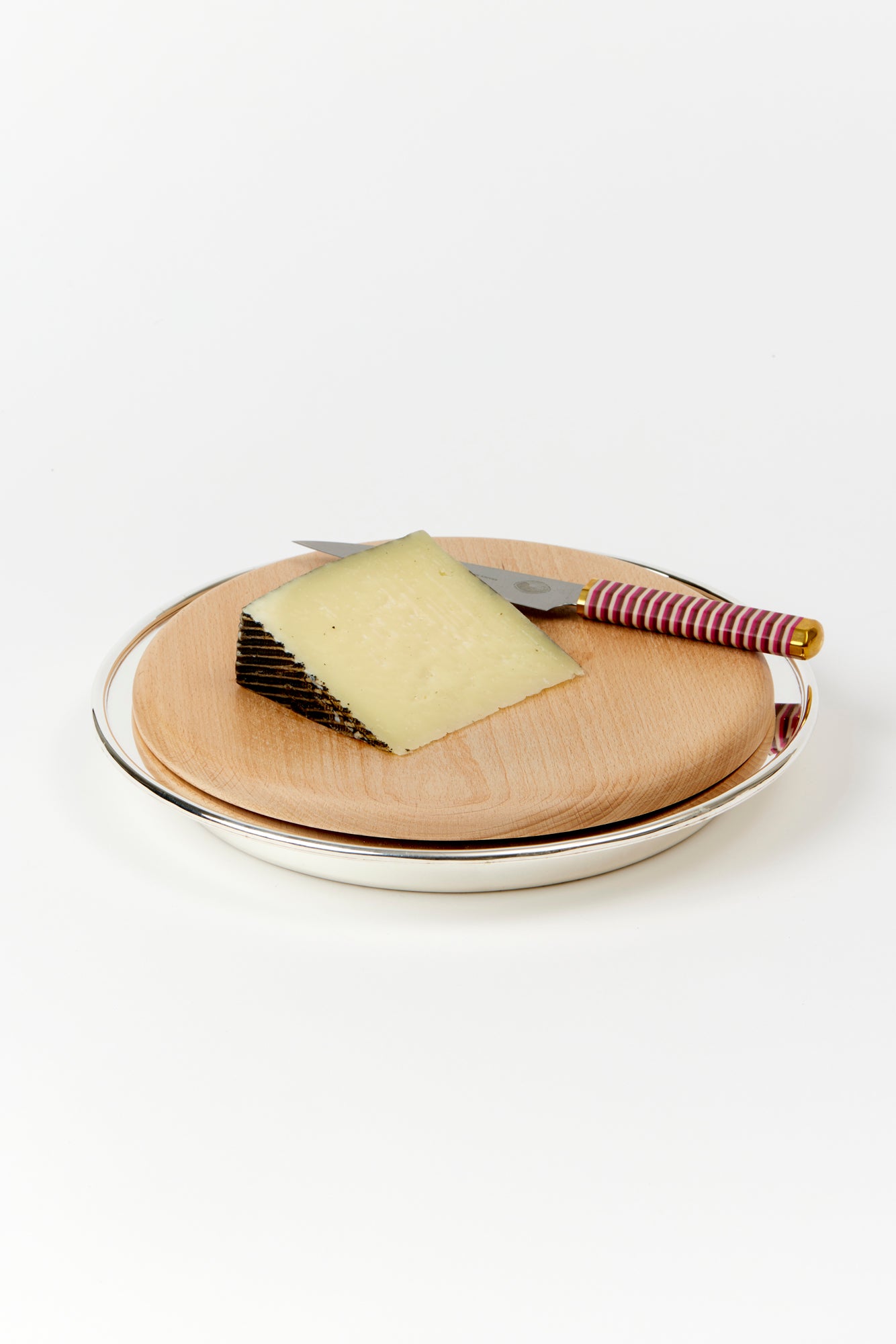 Wood cutting and serving board on a silver-plate stand.