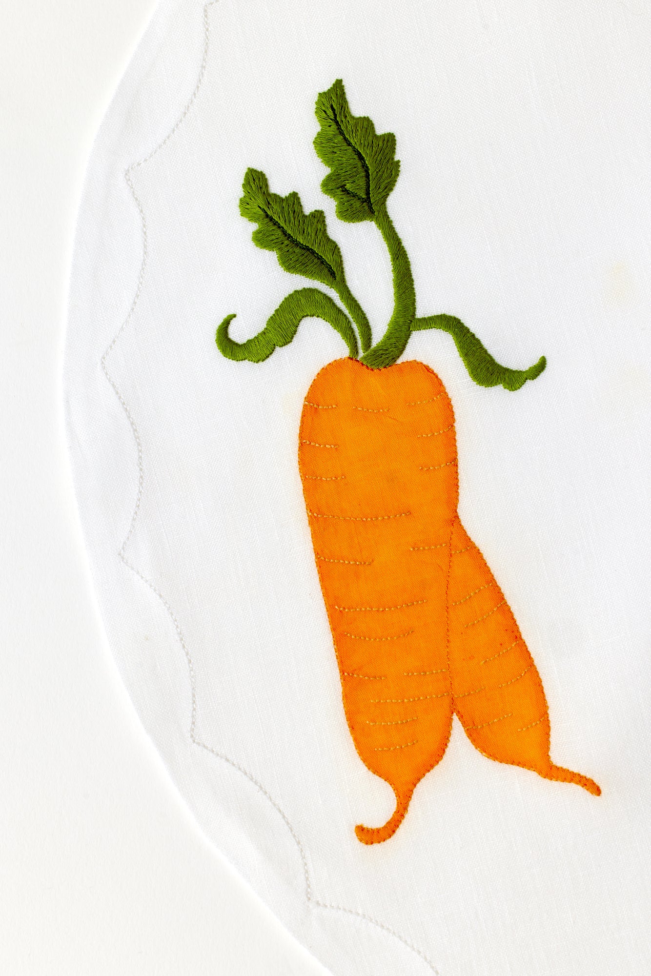 Embroidered carrot on linen.