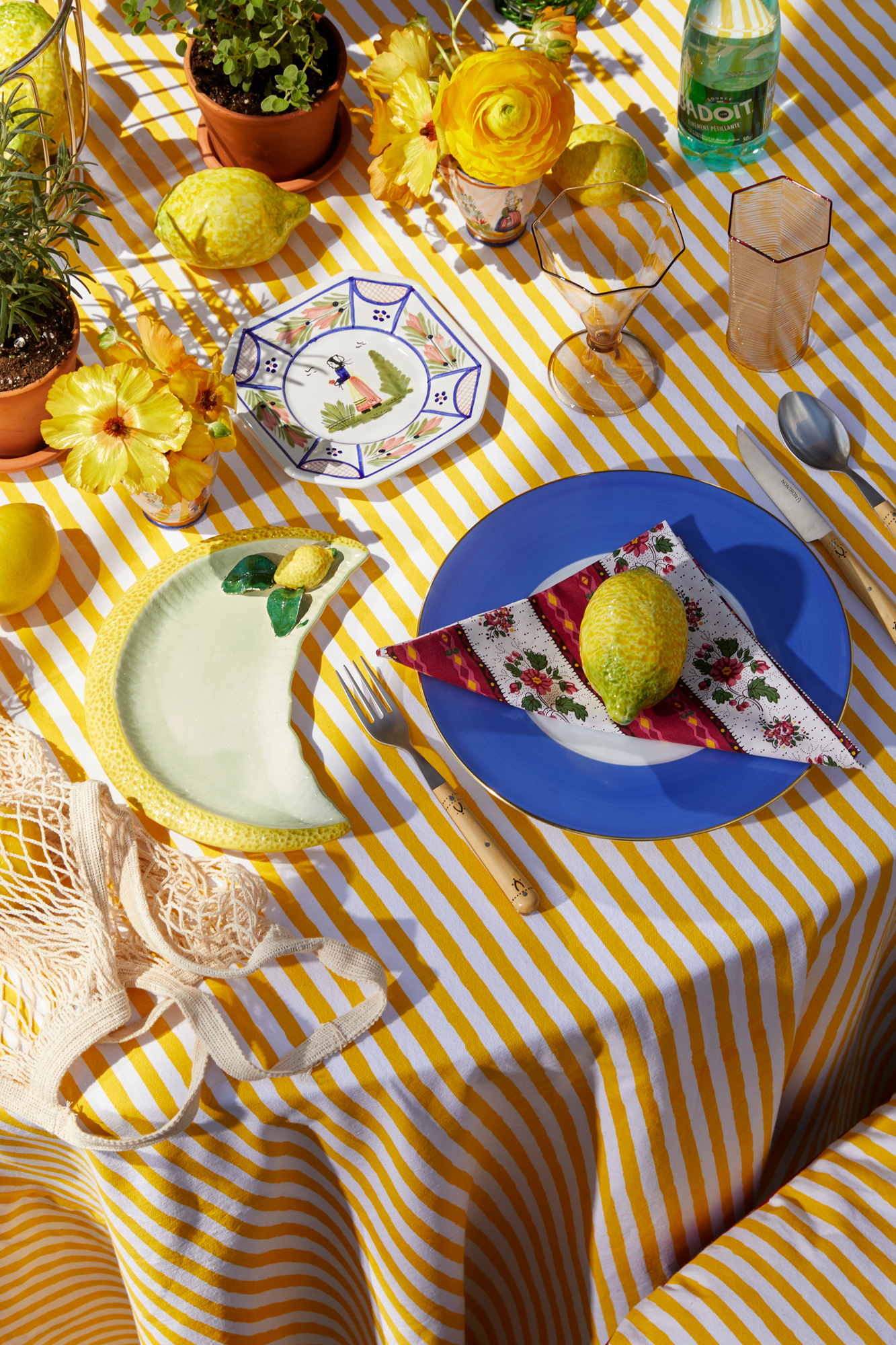 Table setting featuring high end linens, china, flatware, glassware, and other pieces. 